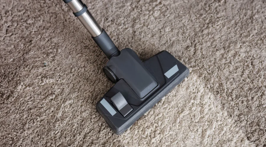 top-view-of-brush-of-vacuum-cleaner-on-dirty-carpe-2.webp